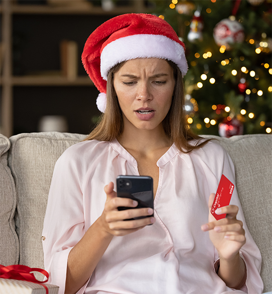 Woman in santa hat holding her smartphone and credit card