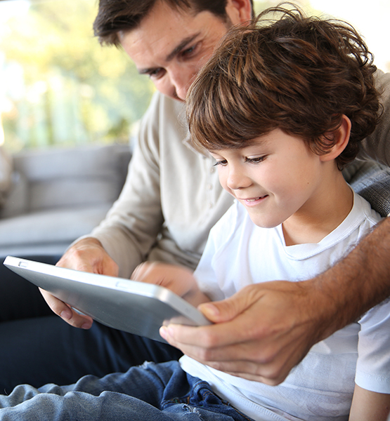 dad and son looking at a tablet