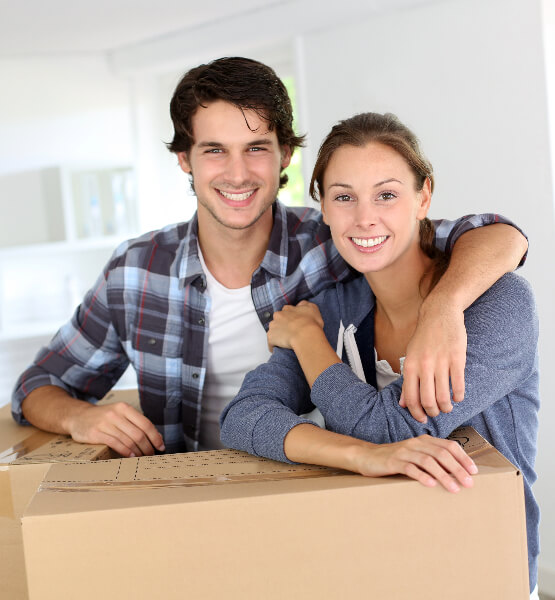 Couple with a moving box, unpacking at new home.
