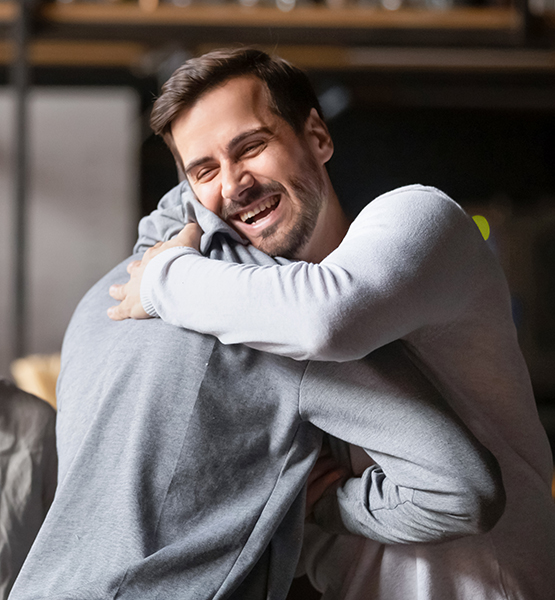 Two middle aged men giving each other a friendly and supportive hug