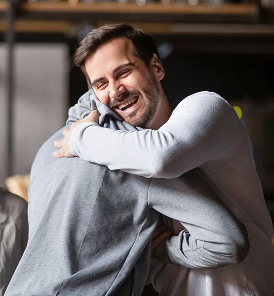 Two middle aged men giving each other a friendly and  supportive hug