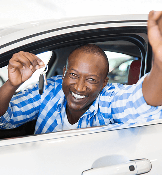 Man sitting in his new car holding the keys. 