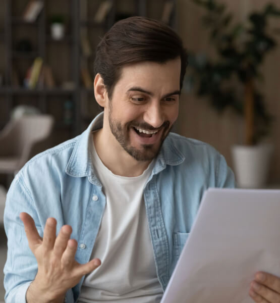 Man looking at a sheet, happy and surprised. 