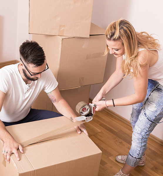 Young man and woman packing belongings and getting ready to move into the new home they purchased