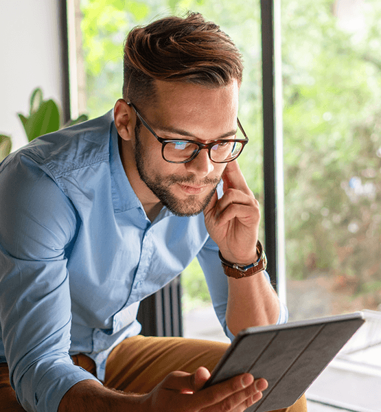 Man with glasses looking at digital banking app on his iPad.