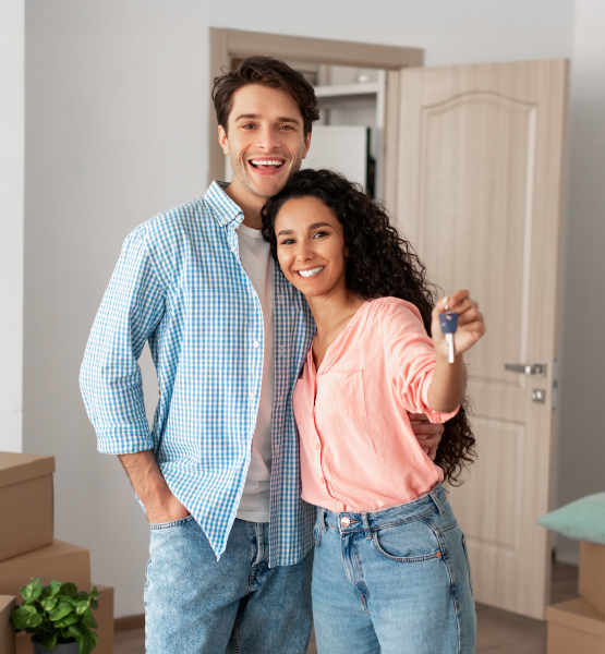 Happy couple holding key to new home. 