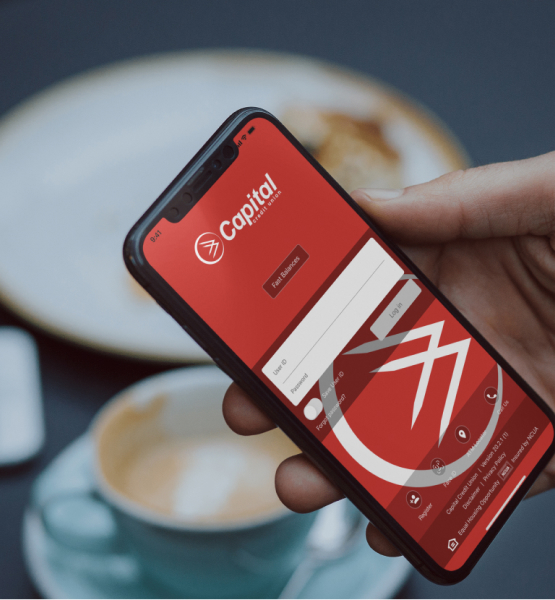 Some one holding a phone with the Capital Credit Union app login screen