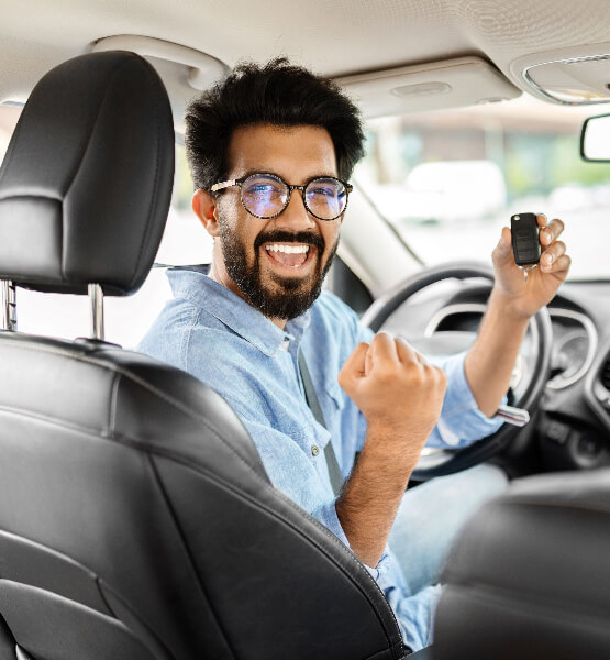 Man holding keys to new car with fist pump.