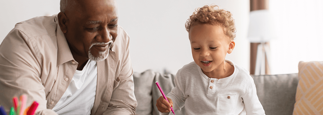 Cute toddler coloring with his dad.