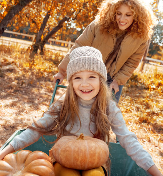 Mom and daughter picking pumpkins.