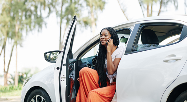 Girl on the phone sitting in her new car.