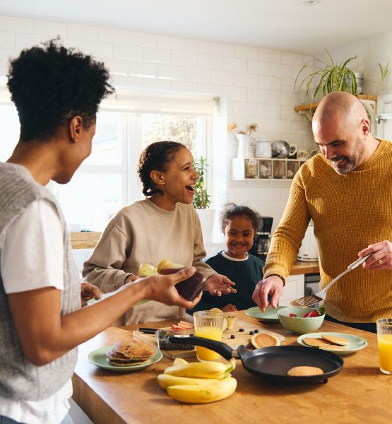 Happy family around kitchen island having breakfast.