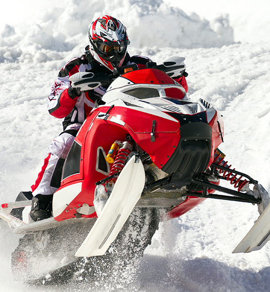 Person riding snowmobile through snow