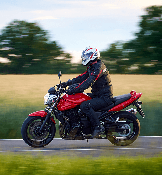Motorcyclist riding black and red Crotch Rocket bike.