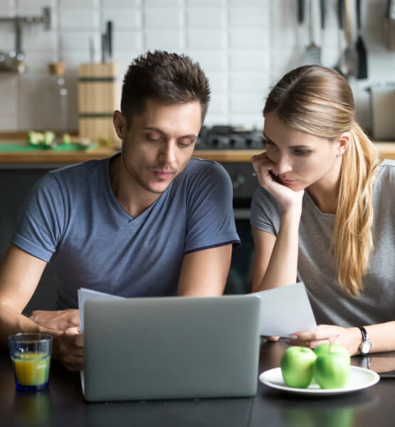 Couple comparing mortgage rates on laptop.