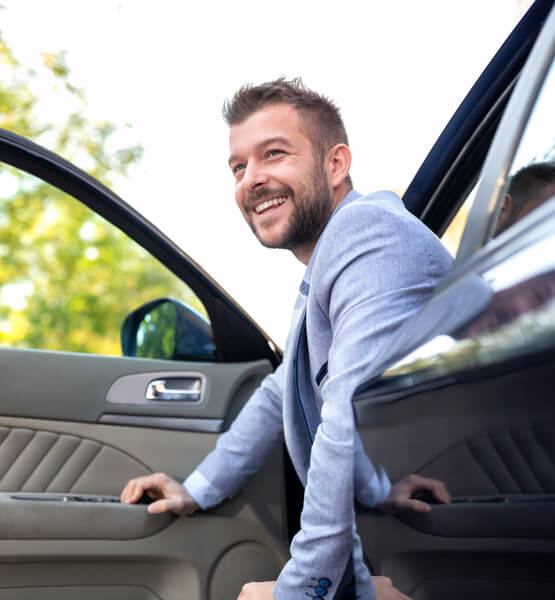 Man sitting in his new car.
