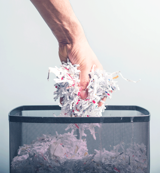 Hand grabbing shredded paper.