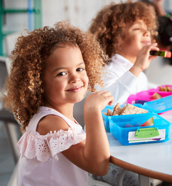 Kids eating lunch at a table.