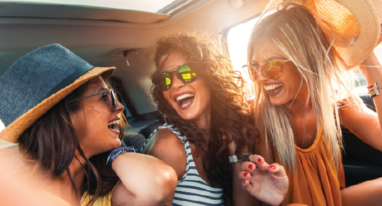 Friends laughing in new car.