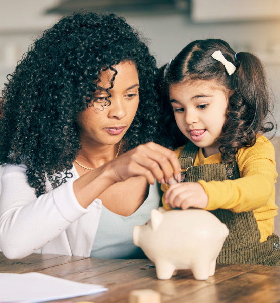 Teaching kid how to save money, putting coin in piggy bank.