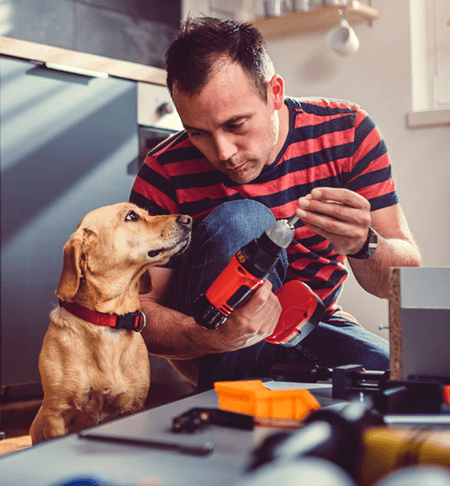 Homeowner and dog by his work station.