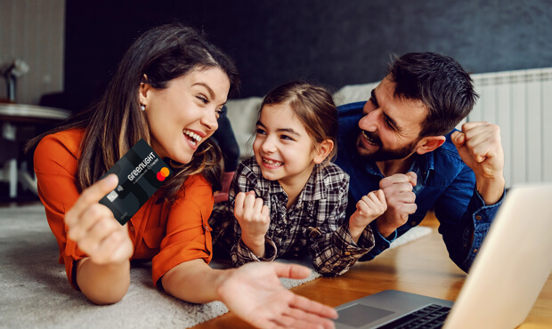Cute family laughing and holding greenlight card. 