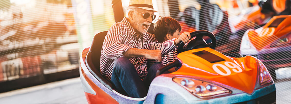 Grandpa and grandkid having fun bumper car.