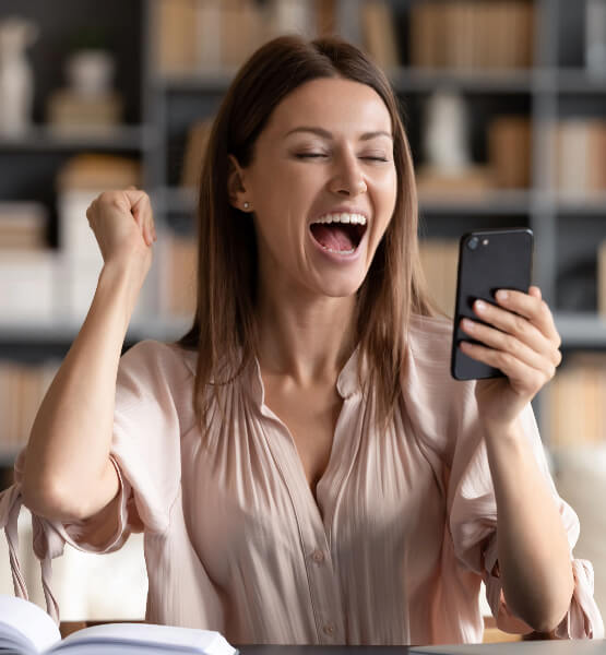 Lady looking at her phone with excitement.