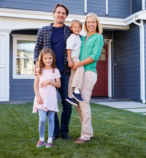 Happy family standing outside of their home.
