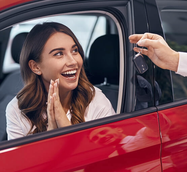 First time auto buyer getting handed keys to new red car financing with Capital CU.