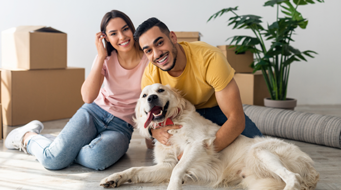 Happy couple and dog in new home.
